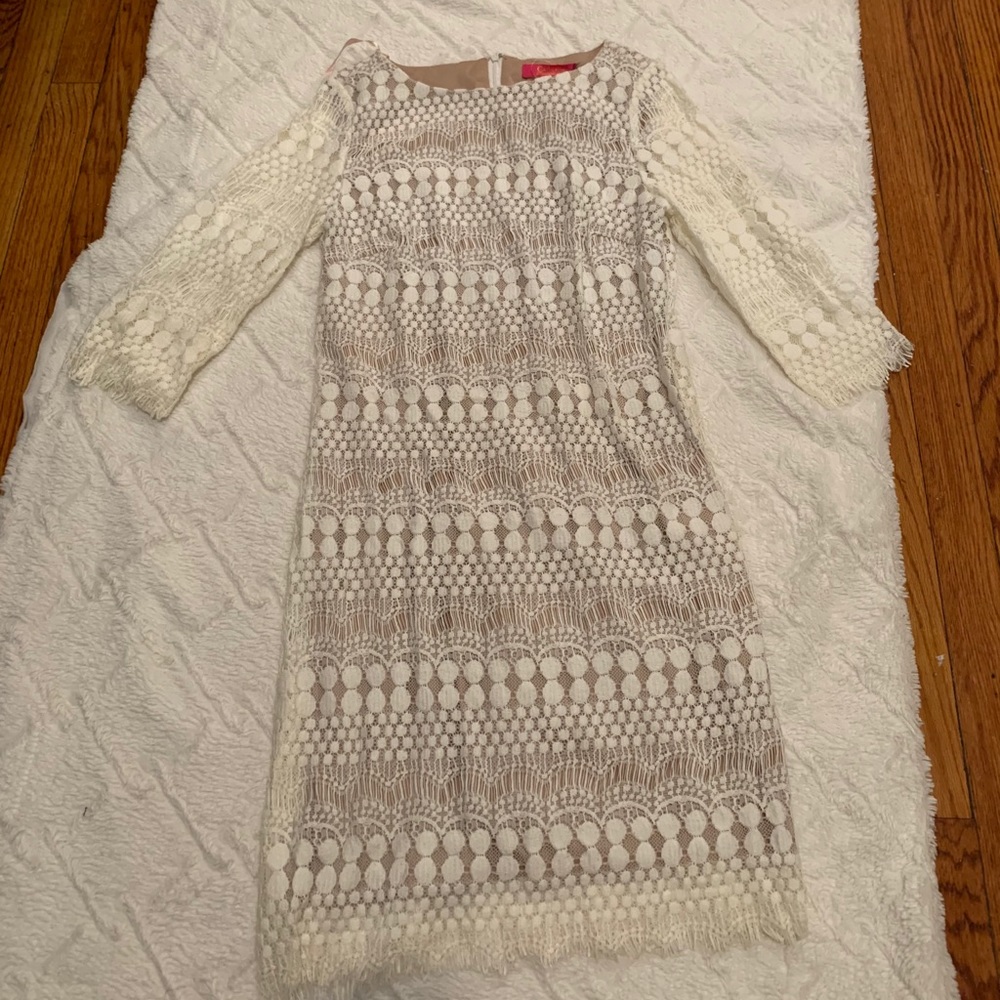 A mid length lace dress with mid leaning sleeves.